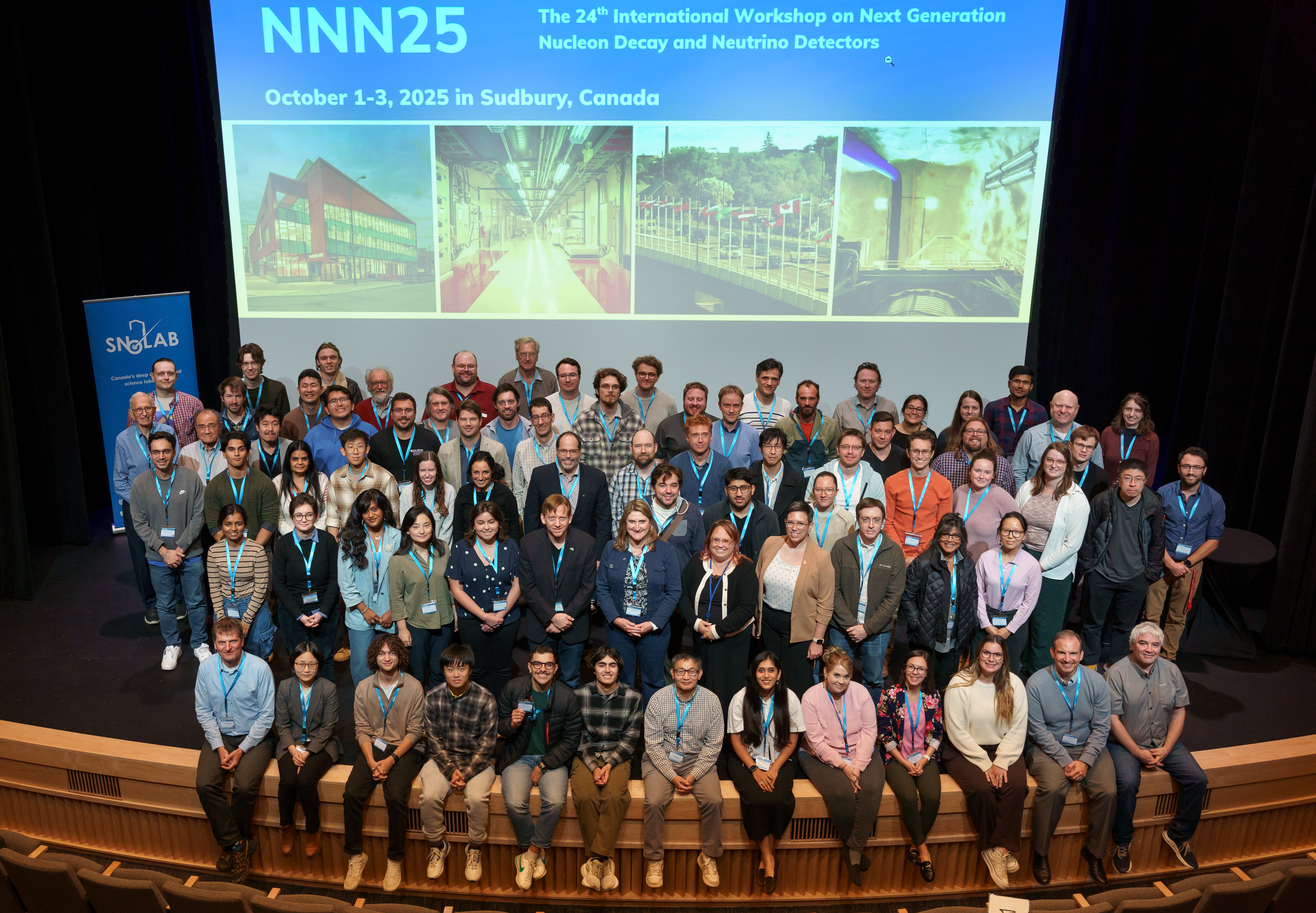 Conference participants sit on stage for a group photograph